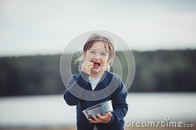 The girl eating blueberries from a glass bowl Stock Photo