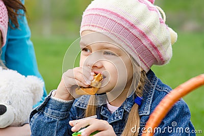 Girl eating cake at a picnic Stock Photo