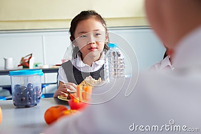 Girl Eating Healthy Packed Lunch In School Cafeteria Stock Photo