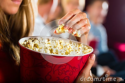 Girl eating popcorn in cinema or movie theater Stock Photo