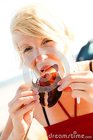 Girl eats lobster claw Stock Photo