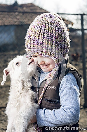 Girl embracing a goatling. Stock Photo