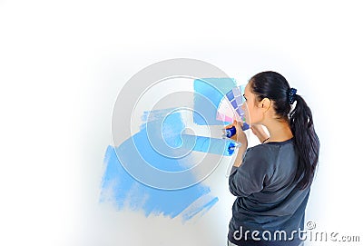 The girl is engaged in a choice of paints for the walls of the room Stock Photo