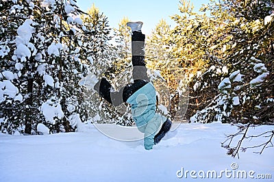 girl is engaged in outdoor sports in early winter morning. Teenage girl does handstand in the snow. Concept of sports Stock Photo