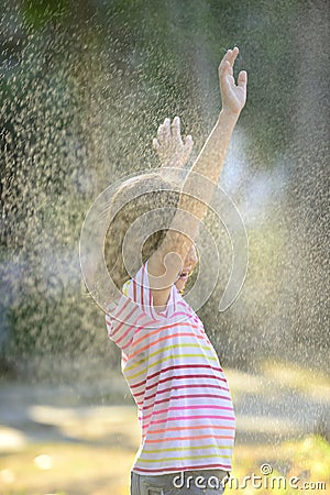 Girl enjoying the light summer rain. Stock Photo