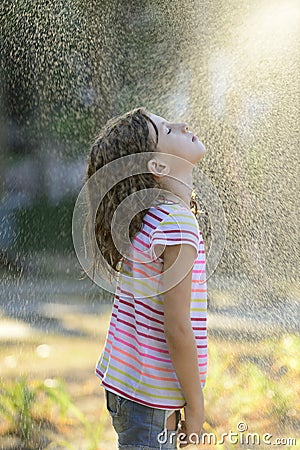 Girl enjoying the light summer rain. Stock Photo