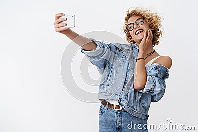 Girl enjoying taking selfie on new smartphone, adoring camera and perfect light for good photo posing laughing happily Stock Photo