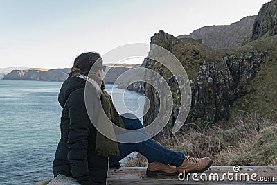 The girl enjoys the view of the cliffs of Northern Ireland Stock Photo