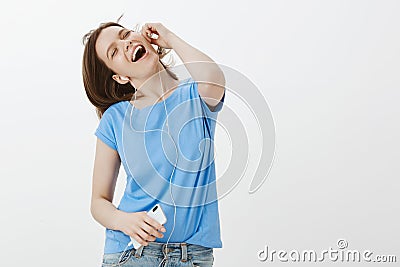 Girl enjoys every bit of new favorite song. Portrait of positive happy young woman in t-shirt, dancing, closing eyes and Stock Photo