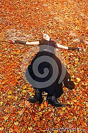 Girl enjoys the last sunbeams in orange autumn Stock Photo