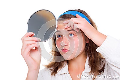 Girl examine her pimples in the mirror Stock Photo