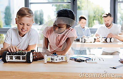 Girl examining the wheel of her friends robotic vehicle Stock Photo