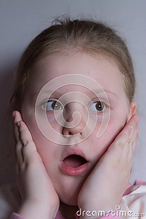 The girl expresses fright on her baby face. Stock Photo