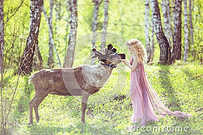 Girl in fairy dress and reindeer in the forest Stock Photo
