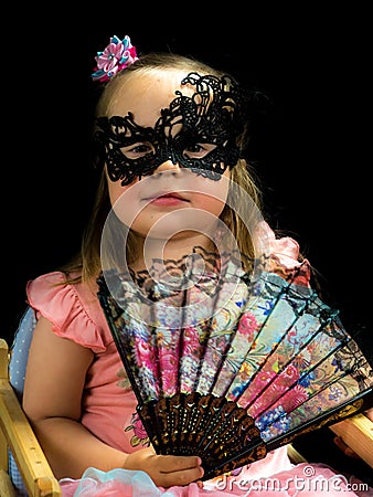 Girl with fan and mask in dress Stock Photo