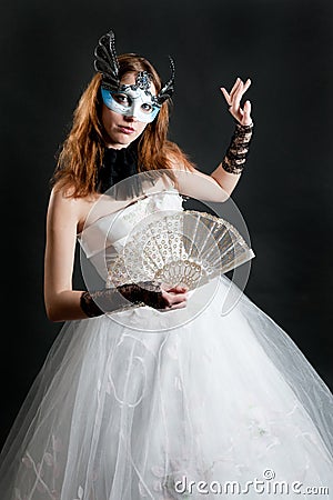 Girl with fan and mask in white dress Stock Photo