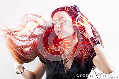 Girl fan sings and dances listening to music. Young brunette woman in big headphones enjoys music Stock Photo