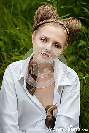 Girl with fashion hairstyle and bright makeup with snails Stock Photo