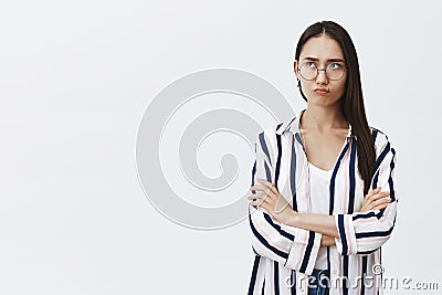 Girl feeling intense regretting missing interesting chance. Cute sulking woman with dark hair in glasses and striped Stock Photo