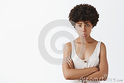 Girl feeling upset and disappointed after losing cometition, standing silly and gloomy with sad expression over gray Stock Photo