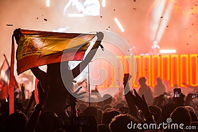 Girl at a festival with a Spanish flag on the shoulders overlooking the crowd Editorial Stock Photo