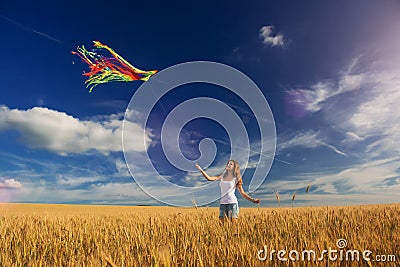 The girl in the field launches a kite Stock Photo