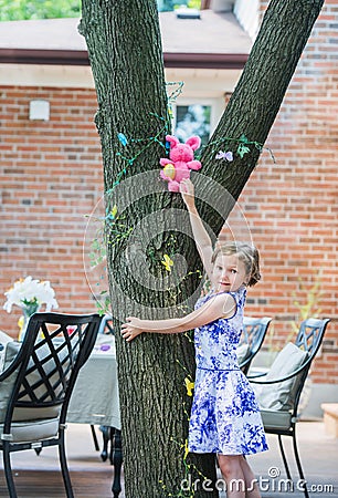 Girl Finds an Easter Egg Up in a Tree Stock Photo