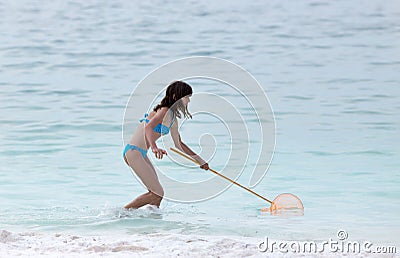 Girl with fishing net on the sea Stock Photo