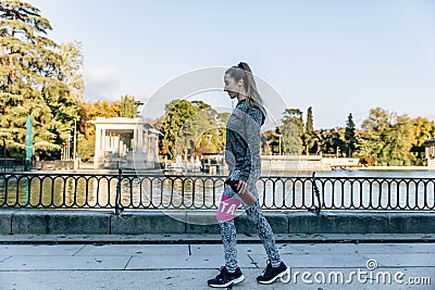 Girl with fitness sportswear walks through a beautiful park Stock Photo