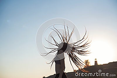 Girl with flying dreadlocks at sunset in profile Stock Photo