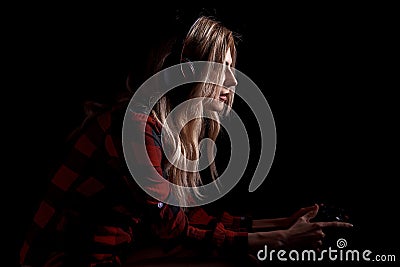 Girl gamer in headphones and with a joystick enthusiastically playing on the console Stock Photo