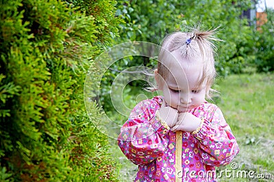 A girl gardener stands near the Christmas trees in a pink jacke. The girl near the tree pondered Stock Photo