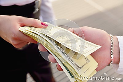 A girl gives a man in the hands of money in the background of an Stock Photo