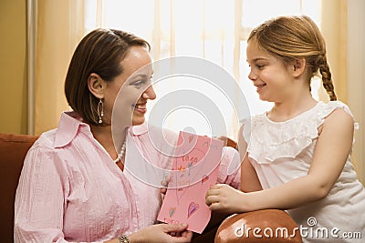 Girl giving mom a drawing. Stock Photo