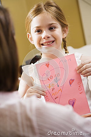 Girl giving mom a drawing. Stock Photo