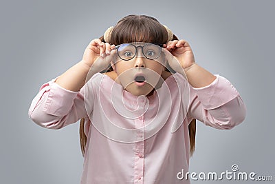 Girl with glasses surprised . disciple shocked. gray background . Stock Photo