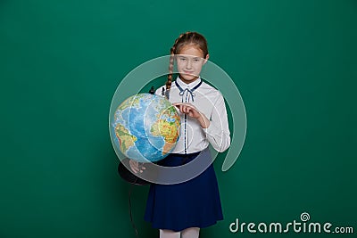 Girl with a globe in geography class at the board at school Stock Photo