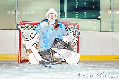 Girl goaltender crouches in crease to protect net Stock Photo