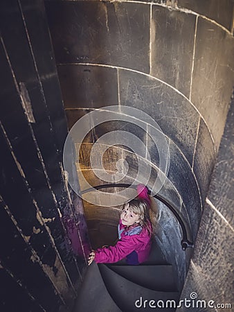 Girl going down the spiral stairs Stock Photo