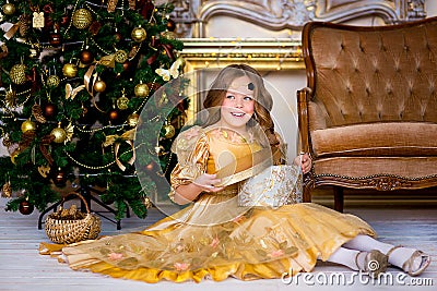 The girl in a gold dress on Christmas Stock Photo