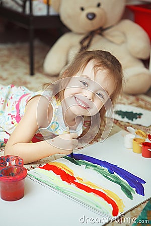 Girl of good mood painting rainbow with brush Stock Photo