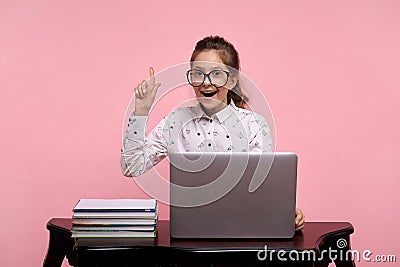 The girl got an idea. Finger raised to the top. A young girl sits at a laptop Stock Photo