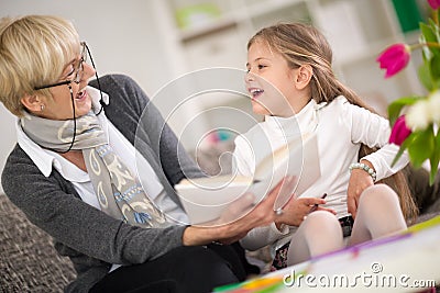 Girl with grandma reading interested book Stock Photo