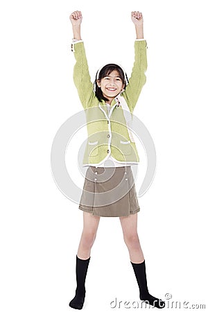 Girl in green sweater and skort standing with arms rasied, happy Stock Photo