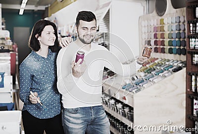 Girl and guy choosing new paint Stock Photo