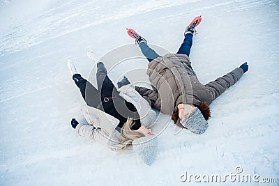 Girl and guy cuddle on snow in skates ice rink in winter, top view. Couple lover holidays Stock Photo