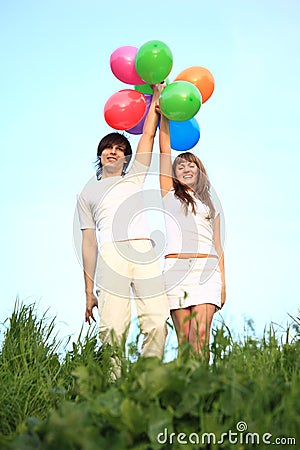 Girl and guy stand with multicoloured balloons Stock Photo