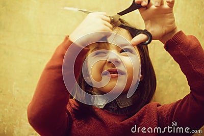 Girl shutting eye from fear while cutting hair Stock Photo