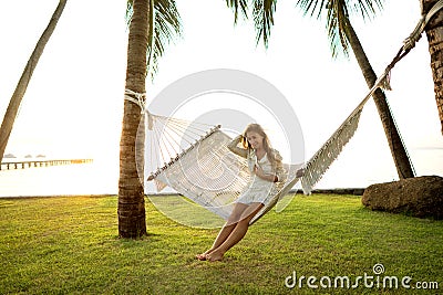 Girl in a hammock bother palm trees enjoying a tropical vacation Stock Photo