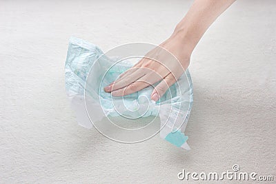 Girl hand touches the moisture absorbency of a baby diaper, close-up Stock Photo